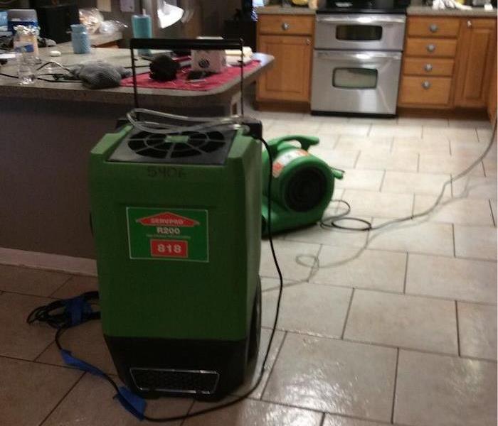 SERVPRO drying equipment in a kitchen with tile floor