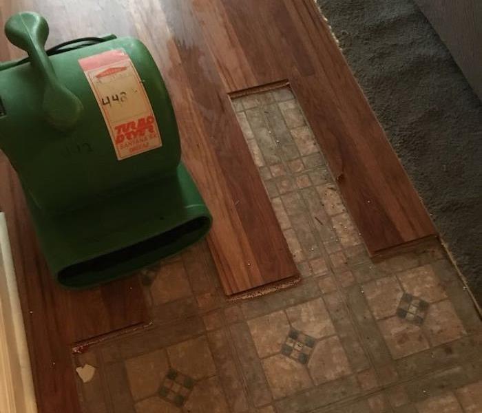 Tile floor and laminate floorboards with SERVPRO drying equipment