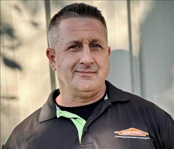 Joseph Paillot, Restoration Manager, in a black HEROReady SERVPRO Shirt standing in front of a white background