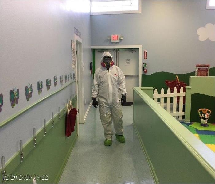 SERVPRO tech, donned in PPE standing in preschool that he just cleaned
