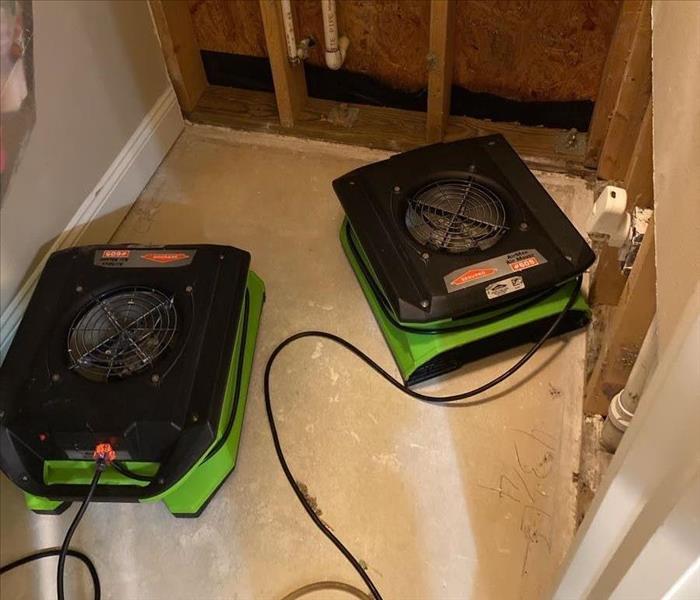 SERVPRO drying equipment in a bathroom with removed fixtures