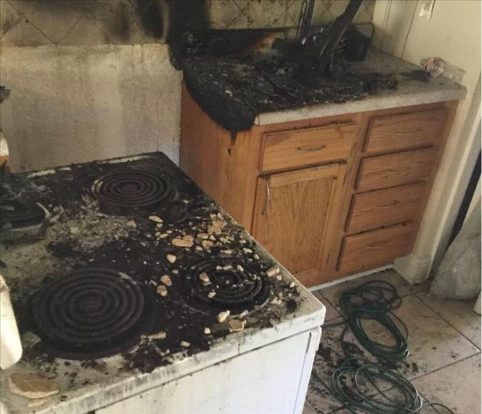 Kitchen with fire damage on stove and sink