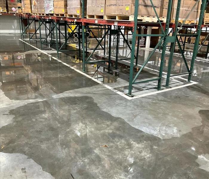 Warehouse with standing water by metal storage racks