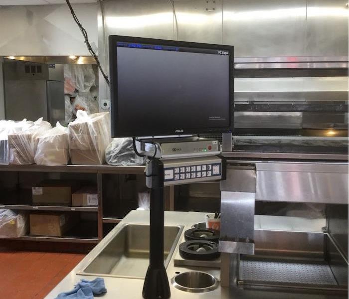 monitor sitting on a stainless steel counter of a commercial kitchen