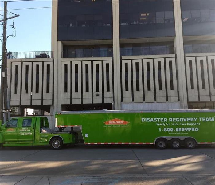 A SERVPRO truck and trailer in front of a building. 